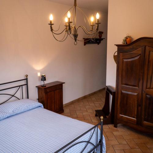 a bedroom with a bed and a chandelier at Agriturismo Casale Piè d'Eco in Calvanico