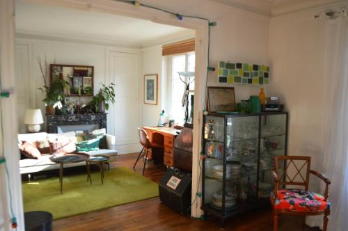 un salon avec un canapé et une table dans l'établissement Chambre dans appartement, à Paris