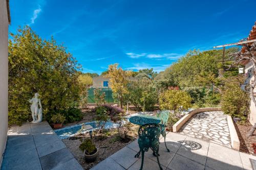 une terrasse avec une table, des chaises et un étang dans l'établissement La Cigale - T2 de plain pied avec piscine partagée, à Puget-Ville