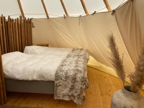 ein Schlafzimmer mit einem Bett in einem Zelt in der Unterkunft Hölick Havsresort & spa in Hudiksvall