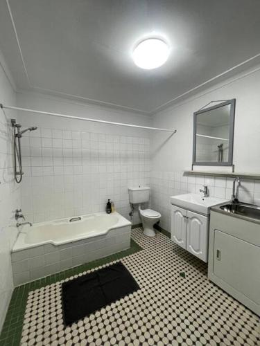 a bathroom with a tub and a toilet and a sink at Close to city 2 Bedroom House Surry Hills in Sydney