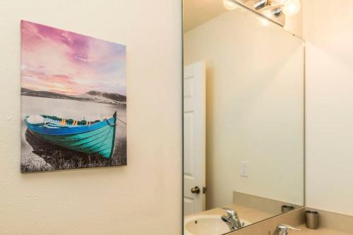 a bathroom with a painting of a boat in a mirror at Roomy Town Home, Mickey-Themed Bedroom! #4BV550 in Kissimmee