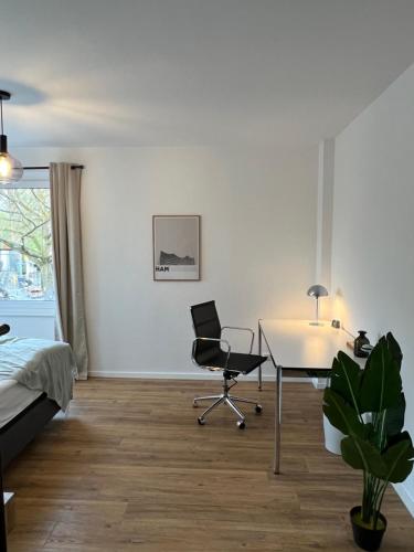 um quarto com uma secretária, uma cadeira e uma cama em Business Apartment Kranich: 3 Zimmer, Top Infrastrukturlage HH Langenhorn, Nähe Airport em Hamburgo