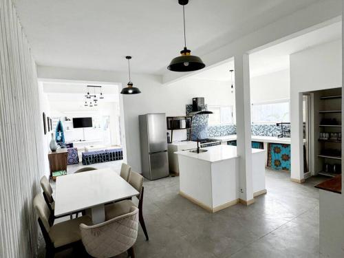een witte keuken met een tafel en een eetkamer bij Escape with a view of the dunes in Santaca