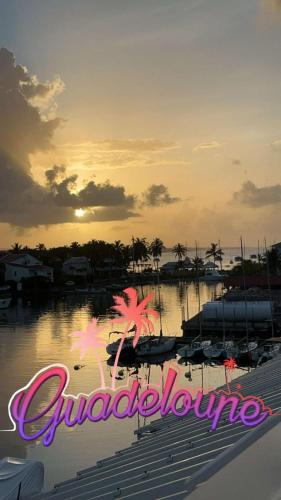 a sunset over a marina with boats in the water at Entre Ciel Et Mer in Saint-François