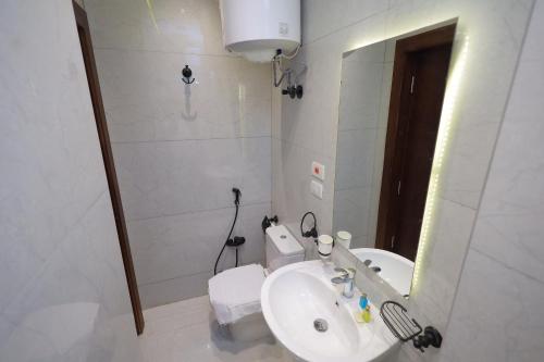a white bathroom with a sink and a mirror at The Muse Pyramids INN in Cairo
