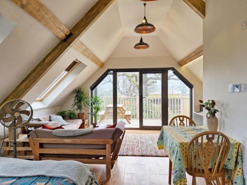 a attic living room with a table and a couch at Broomy Cottage in Pulborough