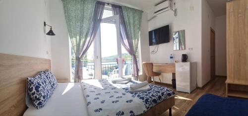 sypialnia z łóżkiem, biurkiem i oknem w obiekcie Laguna Beach Club Bazaleti Lake w mieście Dushetʼi