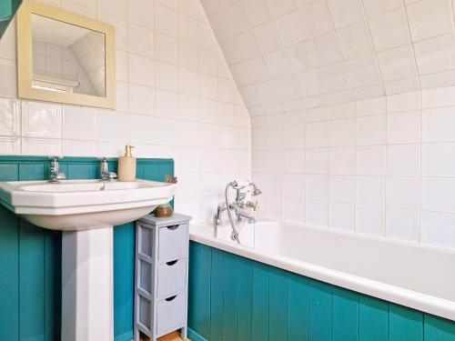 een badkamer met een wastafel en een bad bij Broomy Cottage in Pulborough