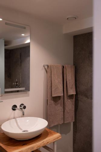 a bathroom with a white sink and a shower at Boutique Hotel Elburg met Tapperij in Elburg