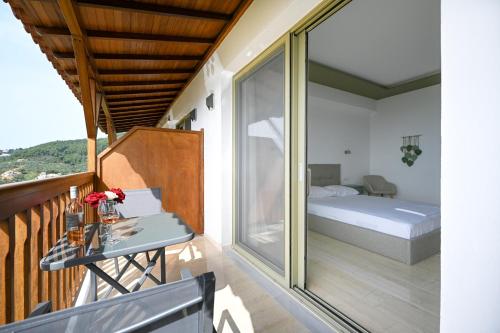 a room with a balcony with a bed and a table at Makis Sea View Studios in Skiathos Town