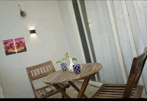 a wooden table and chairs in a room with a window at Vrunda 2BHK spacious and cozy Homestay in Vrindāvan