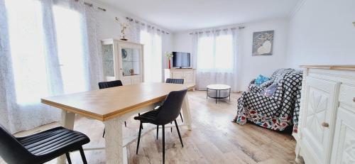 una habitación con mesa y sillas y un dormitorio en Les Glycines - Maison avec bel extérieur, 