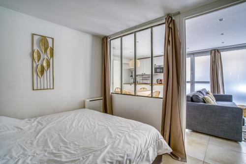 une chambre avec un lit et une grande fenêtre dans l'établissement Nenuphar 3 pièces en RDC Paris 15ème / Felix Faure, à Paris