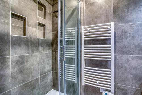 une douche avec une porte vitrée dans une salle de bain dans l'établissement Nenuphar 3 pièces en RDC Paris 15ème / Felix Faure, à Paris