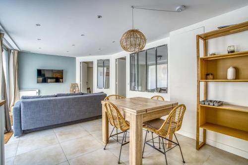 une salle à manger et un salon avec une table et des chaises dans l'établissement Nenuphar 3 pièces en RDC Paris 15ème / Felix Faure, à Paris