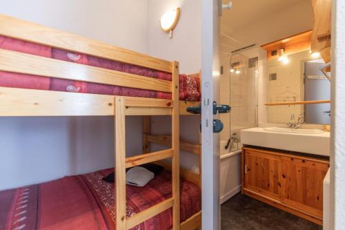 a bedroom with two bunk beds and a bathroom with a sink at BB19 - T2 avec garage privé à Barèges in Barèges