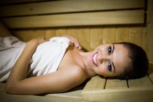 a young woman laying on a bed in a bed at Hotel *** NAT Ustroń in Ustroń
