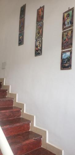 three pictures on the wall of a stair case at LEYO FURNISHED APARTMENTS in Addis Ababa