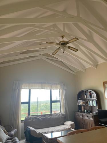 a ceiling with a ceiling fan in a living room at Sea view cottage in Great Brak River