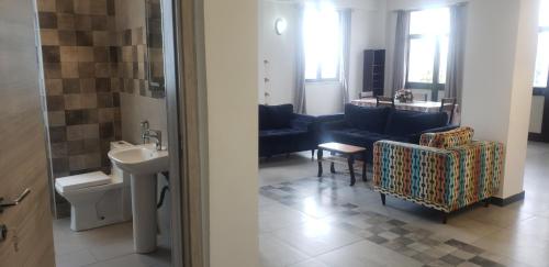 a bathroom with a sink and a living room with a couch at YOLE Furnished Apartments in Addis Ababa