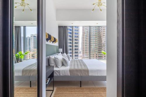 a bedroom with a bed and a large window at Frank Porter - Silverene in Dubai