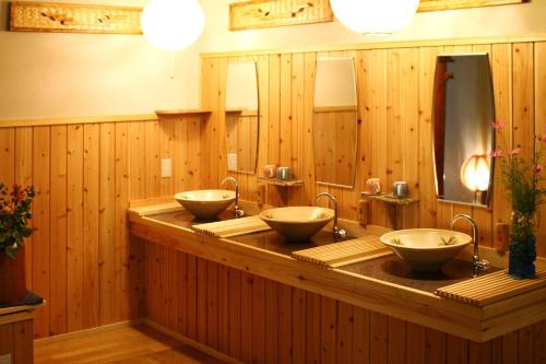 a row of three sinks in a wooden bathroom at Mogamiya Ryokan in Shiroishi