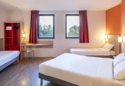ラヴァルにあるB&B HOTEL Laval Ouestのベッド2台とデスクが備わるホテルルームです。