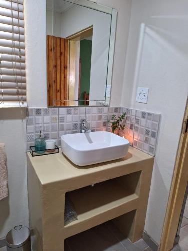 a bathroom with a sink and a mirror at Fraai Maraai Self Catering Apartments in Groblersdal