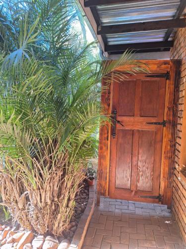 a wooden door on a house with some plants at Fraai Maraai Self Catering Apartments in Groblersdal