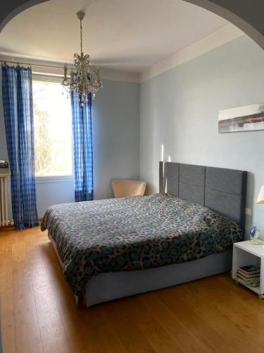 une chambre avec un lit, une fenêtre et un lustre dans l'établissement Villa élégante à Cavaillon avec piscine, à Cavaillon