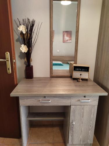 a wooden vanity with a mirror and a laptop on it at APOSTOLIS APARTMENT in Platamonas