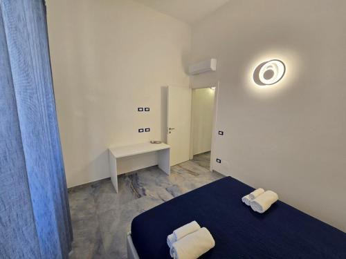 Habitación pequeña con cama y escritorio. en ALG Apartments con Parcheggio en Porto Cesareo