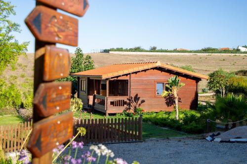 a wooden house with a fence in front of it at Quinta da Relva - Soulful House in Mafra
