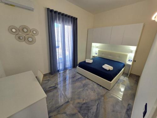um quarto com uma cama azul e um espelho em ALG Apartments con Parcheggio em Porto Cesareo
