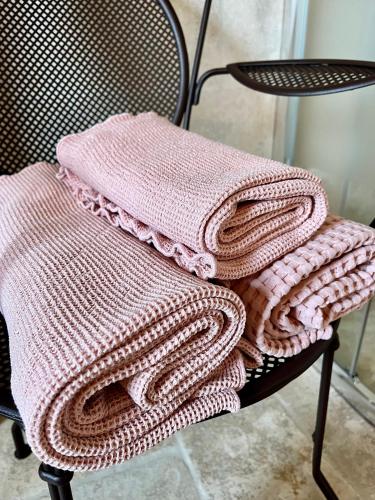 une pile de couvertures posée sur une chaise dans l'établissement Le balcon du fêtre (Maria & Jean Louis Chapuy), à Chiroubles