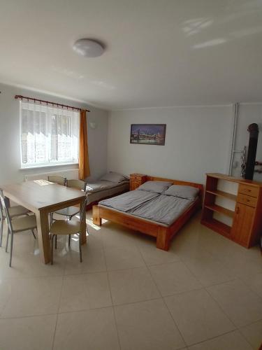 a bedroom with a bed and a desk and a table at Domimat-Lila in Dębki