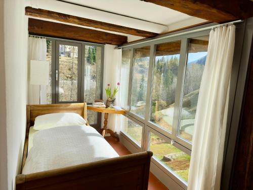 Schlafzimmer mit einem Bett vor einem Fenster in der Unterkunft Antica Osteria Dazio in Fusio