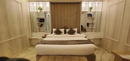 a bedroom with a bed with white sheets and pillows at The Palms Hotel in Abuja