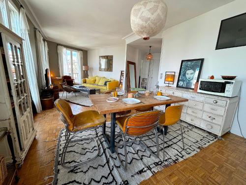 un salon avec une table et des chaises en bois dans l'établissement L'appartement Poulbot, à Paris