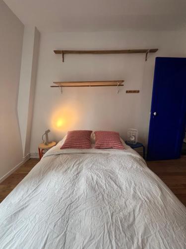 a bedroom with a large white bed with red pillows at Appartement d’artiste in Saint-Denis
