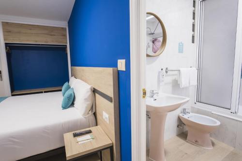ein kleines Bad mit einem Bett und einem Waschbecken in der Unterkunft Alda Coruñamar in A Coruña
