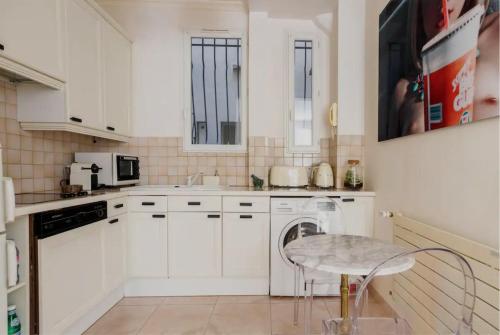 La cuisine est équipée de placards blancs et d'un lave-vaisselle blanc. dans l'établissement Champs-Elysées/President Palace.Terrace & parking, à Paris