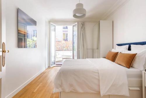 une chambre blanche avec un lit et une fenêtre dans l'établissement Champs-Elysées/President Palace.Terrace & parking, à Paris