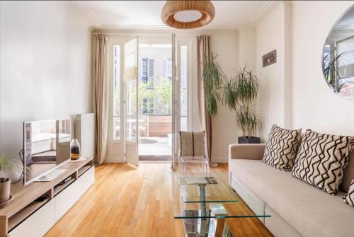 un salon avec un canapé et une table en verre dans l'établissement Champs-Elysées/President Palace.Terrace & parking, à Paris