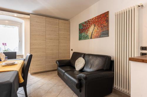 a living room with a leather chair and a table at Casa Nico in Tassullo