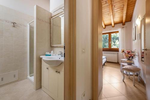 ein Bad mit einem Waschbecken, einer Dusche und einem Spiegel in der Unterkunft Residence Tatiana B1 in Tremosine sul Garda