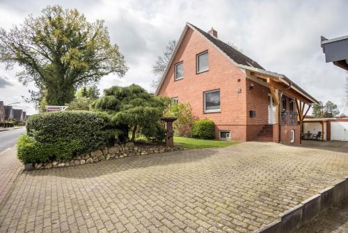 a brick house with a stone driveway at Ferienwohnung Krempermoor 1 in Krempermoor