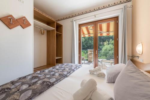 a bedroom with a bed and a large window at Residence Tatiana A3 in Tremosine Sul Garda