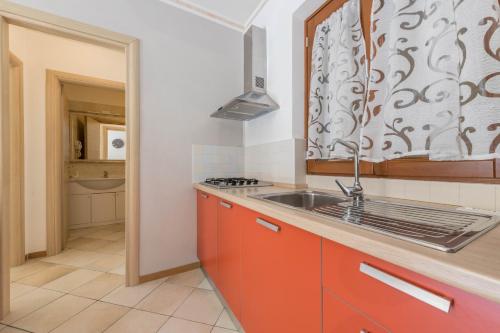 a kitchen with orange cabinets and a sink at Residence Tatiana A3 in Tremosine Sul Garda